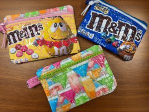 three zipper bags made from fabric with candy on it.